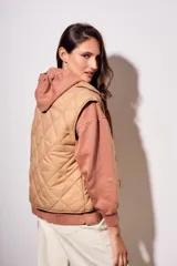 Chaleco acolchado color camel con diseño de rombos. Interior con estampado floral.