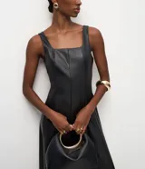 Vestido midi negro de cuero sintético (poliuretano), con escote cuadrado, tirantes anchos y diseño ajustado con costuras verticales estructuradas.