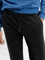 Pantalón de jogging azul marino, confeccionado en felpa, con cintura elástica ajustable con cordón y puños acanalados en los tobillos.