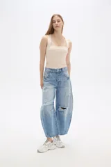 Pantalón de jean celeste con roturas, pinzas y corte barrel.