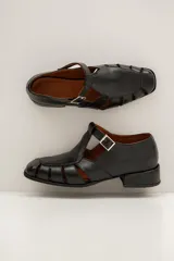 Sandalias Mary Jane de cuero color bordeaux, con diseño de tiras cruzadas, puntera cuadrada y taco bajo.