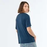 Remera de algodón color azul, de corte holgado, mangas cortas y cuello redondo. Cuenta con una pequeña etiqueta blanca decorativa en el borde inferior izquierdo.