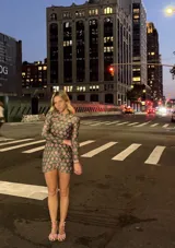 Vestido corto ajustado de manga larga con estampado de conchas marinas en tonos rosa y verde.