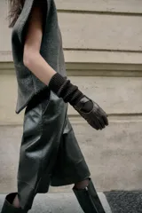 Guantes largos combinados con efecto piel y tejido de punto acanalado de lana. Presentan un diseño con abertura en el dorso y detalle de botón a presión.