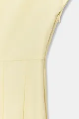 Vestido largo de Zara Woman Collection color amarillo claro, confeccionado en mezcla de algodón. Cuenta con escote en V, manga corta, corte en la cintura y falda evasé con pliegues marcados.