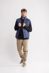 Chaleco puffer azul marino con cuello alto y cierre frontal.