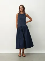 Vestido midi azul marino, sin mangas, con corte recto en la parte superior y falda amplia fruncida.