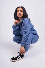 Pantalón de jogging color beige con cintura elástica y logo estampado en blanco en el muslo.