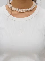 Musculosa básica de algodón con textura acanalada, diseño crop y logo bordado centrado en el pecho.