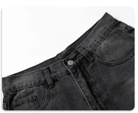 Jean de corte ancho y holgado, color negro lavado con efecto desgastado y roturas visibles en la parte delantera de las piernas. Presenta cinco bolsillos.