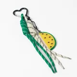Llavero con mosquetón en forma de corazón, compuesto por cordones de nylon trenzados en colores verde y blanco, y un dije colgante de resina con forma de rodaja de sandía amarilla.
