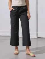 Pantalón jogger color crema, de corte ancho, con pretina elastizada y lazo de ajuste.