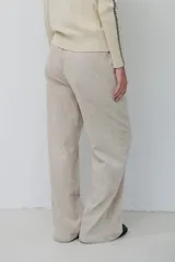 Pantalon de pana color beige, de corte recto y tiro alto, con bolsillos laterales y cintura elástica.