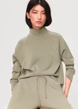 Pantalón de pierna ancha color verde militar, confeccionado en tejido de modal, poliéster y elastano, con cintura elástica con cordón ajustable y bolsillos laterales.