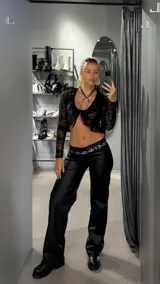 Pantalón negro de eco cuero con corte wide leg y tiro bajo.