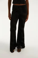 Pantalón negro de corte oxford y fluido, confeccionado en tejido de tul devoré con un delicado diseño estampado de flores en tono sobre tono.