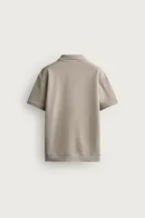 Polo regular fit color verde militar con textura acanalada vertical, cuello solapa con abertura frontal, manga corta y acabados en rib.