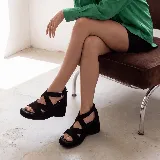 Sandalia de cuero marrón con plataforma y taco cuña de madera, tiras cruzadas en el empeine y tira ajustable con hebilla en el tobillo.