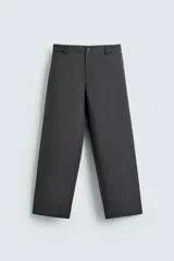 Pantalón de corte relajado en color gris oscuro, con cintura elástica ajustable, cierre frontal con cremallera y botón, bolsillos laterales y bolsillo trasero de plastrón.