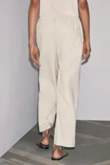 Pantalón jogger de la colección Zara Woman, color gris claro, confeccionado en hilatura con algodón y lyocell. Presenta tiro medio, cintura elástica ajustable con cordones, bolsillos laterales ocultos en costura y pierna ancha.