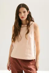 Top de lino color beige claro, sin mangas, con cuello redondo y vivos en color bordó que realzan la figura.