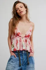 Top estilo babydoll de viscosa color rosado con estampado floreado, escote en V pronunciado, tirantes finos y detalles de volados combinados con paneles en tono crudo.