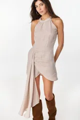 Vestido corto de lino celeste, con escote halter, falda drapeada asimétrica y cierre invisible en el lateral.