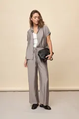 Pantalón gris de corte amplio y silueta fluida, con cintura elástica y cordón ajustable.