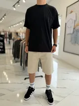 Bermuda baggy de jean color beige, de corte holgado y diseño clásico de cinco bolsillos.