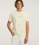 Remera de algodón color amarillo claro, de corte cómodo y manga corta, con cuello redondo y estampa pequeña con la frase "Nascido num País Tropical" en el pecho.