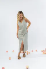 Vestido largo de lino con escote en V, diseño recto y fluido, con cierre frontal abotonado mediante botones de madera.