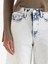 Jeans wide leg cropped de denim color blanco suave con efecto de lavado ácido (bleach wash). Presenta tiro medio y diseño de pernera ancha.