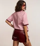 Short pollera de tiro medio confeccionado en poliuretano con acabado símil cuero. Presenta diseño de corte recto, cierre frontal con cremallera, trabillas para cinturón y dos bolsillos delanteros con solapa.