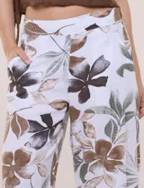 Pantalón crop de lino y rayón, con diseño wide leg de corte holgado, estampado tropical de hojas en tonos verde, azul y marrón sobre fondo blanco. Cuenta con pretina trasera elastizada y bolsillos delanteros.