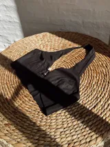 Top negro con escote halter y abertura en el centro del busto con detalle de argolla metálica.