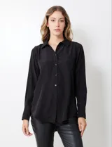 Camisa de satén color violeta, con cuello clásico, cierre frontal con botones, manga larga con puños anchos abotonados y bolsillo aplicado en el pecho.