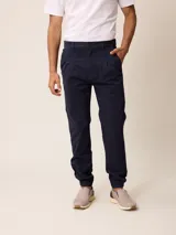 Pantalón bombacha de sarga azul marino, con pinzas en la cintura, bolsillos laterales y puños elásticos en los tobillos.