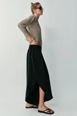 Pantalón fluido de tiro alto en color blanco, con pinzas delanteras, cintura elástica en la espalda y perneras anchas con aberturas laterales pronunciadas.