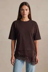 Remera marrón oversize de algodón peinado con cuello redondo, mangas cortas y detalle de ruedo asimétrico en satén con aplicación de encaje.