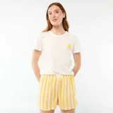 Conjunto de pijama compuesto por una remera blanca de manga corta con pequeño estampado de sol y la frase 'Sunshine' en el pecho, y un short a rayas verticales en tonos amarillo y rosado con elástico en la cintura y etiqueta con la palabra 'Love.'.