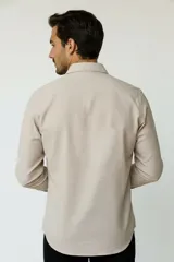Camisa de poliéster color marrón, de corte holgado, con mangas largas, cuello camisero clásico y cierre frontal de botones.