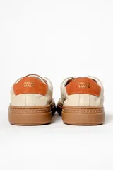 Zapatillas blancas de cuero con detalles en negro en el talón y la lengüeta.