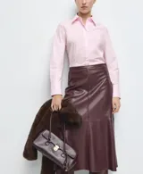 Camisa entallada de popelín de algodón color rosado, con cuello camisero, manga larga y cierre frontal oculto con botones bajo tapeta.