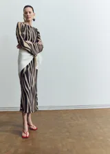Vestido midi de poliéster con estampado animal print tipo cebra en tonos marrón y negro, escote redondo y manga larga.