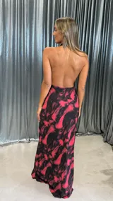 Vestido largo de fiesta con estampado abstracto en tonos negro y fucsia, diseño con escote halter y cuello drapeado.