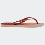 Ojotas Havaianas Slim Palette Glow con base estampada en tonos rosa, naranja y marrón, tiras finas color cobre y logo de la marca en las tiras.
