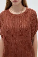 Remera de manga corta de acrílico en tejido calado, con cuello redondo y diseño ajustado.