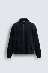 Cazadora regular fit confeccionada en pana de algodón con interior ligeramente acolchado. Presenta cuello solapa, cierre frontal con cremallera, bolsillos laterales de vivo y acabados en rib en puños y cintura.