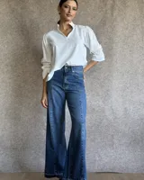 Pantalón de jean estilo wide leg con costuras verticales frontales, tiro alto y bolsillos laterales.