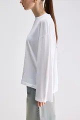 Remera de manga larga color gris verdoso, de calce relajado, con cuello redondo y mangas amplias.